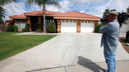 Stephen Coleman, a cameraman for ABC News, photographs the home believed to be the residence of a household staff member who mothered a child with former Gov. Arnold Schwarzenegger, Wednesday, May 18, 2011, in Bakersfield, Calif. (AP Photo/Nick Ut)