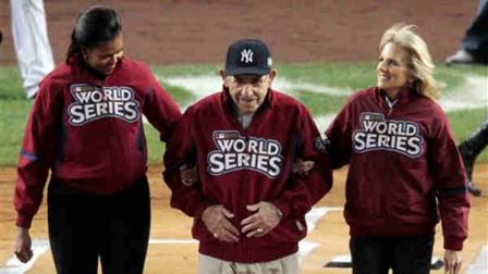 First Lady Michelle Obama, left, and Jill Biden, wife of Vice-president Joe Biden, escort former Yankee Yogi Berra to the pitchers mound before Game 1 of the Major League Baseball World Series Wednesday, Oct. 28, 2009, in New York. (AP Photo/Eric Gay)