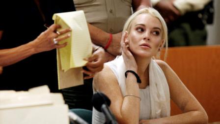 Lindsay Lohan, right, alongside her attorney Shawn Chapman Holley, is shown before being taken into custody by Los Angeles Country sheriffs deputies after a judge found her in violation of probation Wednesday, Oct. 19, 2011, in Los Angeles.
