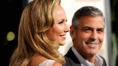 Stacy Keibler poses for photographers as her boyfriend George Clooney, a cast member in The Descendants, looks on at the premiere of the film, Tuesday, Nov. 15, 2011, in Beverly Hils, Calif. The film is released in New York and Los Angeles on Wednesday, and theaters nationwide on Friday.