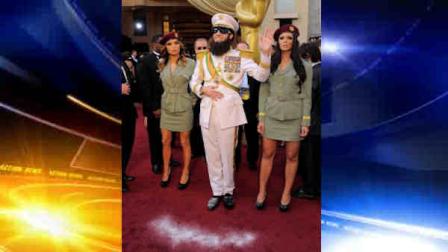 Sacha Baron Cohen, center, smiles after dropping a substance on the red carpet as he arrives before the 84th Academy Awards on Sunday, Feb. 26, 2012, in the Hollywood section of Los Angeles. (AP Photo/Chris Pizzello)