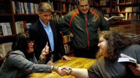 Author E L James, left, greets Linda Tyndall during a book signing for her new erotic fiction Fifty Shades of Grey in Coral Gables, Fla., Sunday, April 29, 2012. Publicist Russell Perreault watches at rear. (AP Photo/Jeffrey M. Boan)