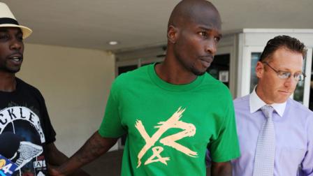 In this Aug. 12, 2012 photo, Chad Johnson, center, leaves Broward County Jail in Fort Lauderdale, Fla. The Dolphins terminated the six-time Pro Bowl receivers contract about 24 hours after he was arrested in a domestic battery case involving his wife. Johnson was released from jail on $2,500 bond after his wife accused him of head-butting her during an argument in front of their home. (Photo by Jeff Daly/Invision/AP)