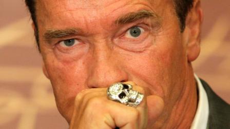 Arnold Schwarzenegger puts his hand over his mouth as he attends a press conference to promote the French version of his new book Total Recall: My Unbelievably True Life Story in Paris, Friday, Oct. 12, 2012. (AP Photo/Francois Mori)