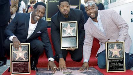 The R&B group Boyz II Men, from left, Shawn Stockman, Nathan Morris and Wanya Morris, touch their new star on the Hollywood Walk of Fame at dedication ceremonies in Los Angeles Thursday, Jan. 5, 2012. (AP Photo/Reed Saxon)