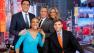 This Feb. 20, 2013 photo released by ABC shows Robin Roberts, left, George Stephanopoulos, (standing, from left) Josh Elliott, Sam Champion, and Lara Spencer, on the set of Good Morning America in New York. Five months after undergoing a bone marrow transplant, Roberts is back on television in the morning. Roberts said Wednesday shed been waiting 174 days to say this, good morning America. The morning-show host is recovering from MDS, a blood and bone marrow disease. (AP Photo/ABC, Heidi Gutman)  