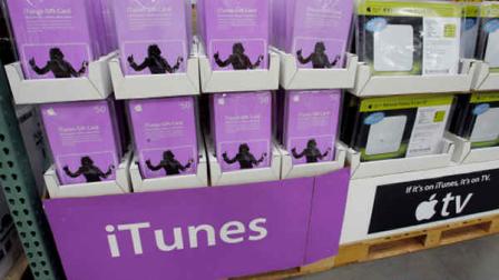Apple iTunes Gift Cards and Apple TV on display at Costco store in San Jose, Calif., Tuesday, Oct. 9, 2007. Apple Inc. is lowering the prices of songs it sells online without copy-protection to 99 cents from $1.29, a company spokeswoman said Tuesday. The reduction, which started appearing on songs Tuesday, puts Apple closer in line with rival offerings. Amazon.com Inc., which opened its online music store in September, sells tracks without anti-copying software locks for 89 cents to 99 cents. (AP Photo/Paul Sakuma)