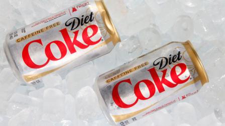This Monday, Oct. 15, 2012 photo shows two cans of Caffeine Free Diet Coke on ice in Surfside, Fla. Coca-Cola is expected to report earnings, Tuesday, Feb. 12, 2013. (AP Photo/Wilfredo Lee)