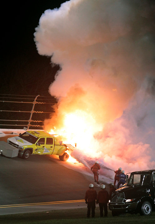 Emergency workers try to put out a fire after...