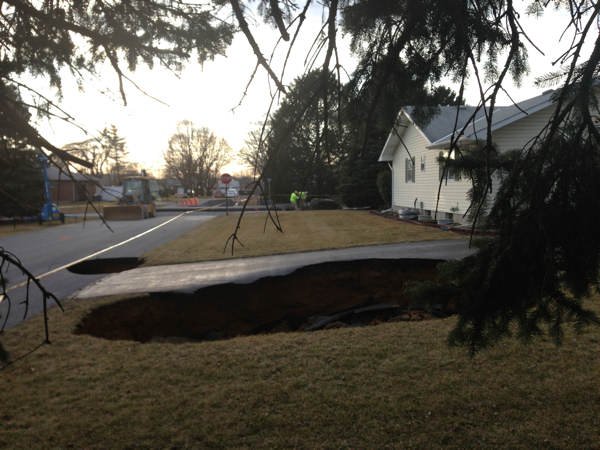 A massive sinkhole, at least 30 feet wide and...