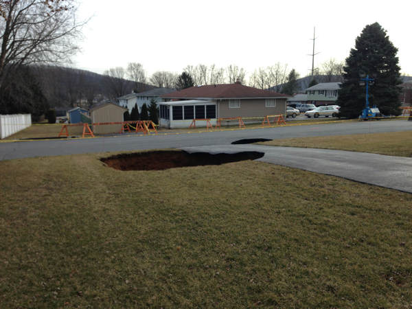 A massive sinkhole, at least 30 feet wide and...