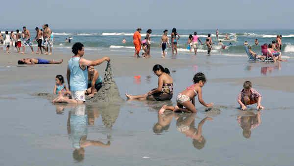 People enjoy the mild weather as they play in a pool of water near the Atlantic Ocean Friday, July 4, 2008, in Wildwood, N.J. (AP Photo/Mel Evans)