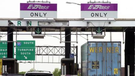 In this May 12, 2003, file photograph, cars and a truck go through the E-ZPass lanes at Exit 8A of the New Jersey Turnpike in Monroe Township, N.J.