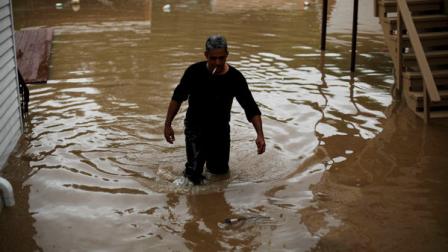 Mario Ortiz, walks through floodwaters next to his home Thursday, Sept. 8, 2011, in Wilkes-Barre, Pa. Widespread flooding brought on by the remnants of Tropical Storm Lee was being blamed for two deaths in Pennsylvania, where inundated communities were evacuated and state offices closed down on Thursday because of the rising waters.