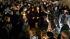 People gather at a statue of former Penn State...
