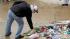 A man places a rose at the foot of a statue of...