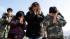 A family observes a moment of silence in front...