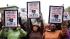 Demonstrators hold up signs during a rally for...