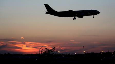 A UPS airplane lands at Newark Liberty International Airport as the sun sets, Wednesday, April 25, 2012, in Newark, N.J. (AP Photo/Julio Cortez)