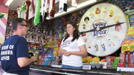 Martin Silva, left, a senior inspector with the New Jersey Department of Community Affairs, asks the operator of a game on the Seaside Heights N.J. boardwalk to demonstrate the operation of her spinning wheel game Thursday, May 31, 2012. Inspectors were checking to see if games were rigged against customers. The wheel game checked out fine. (AP Photo/Wayne Parry)
