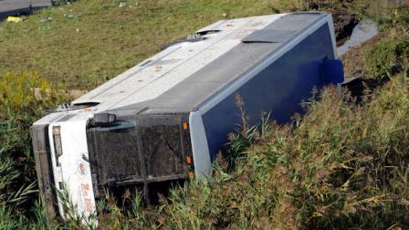 A bus sits in a ditch after it overturned coming off an exit ramp on Route 80 in Wayne, N.J. Saturday, Oct. 6, 2012. The chartered tour bus from Toronto carrying about 60 people overturned on an interstate exit ramp. Three people have been taken to hospital with non-life-threatening injuries. (AP Photo/Bill Kostroun)