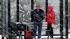 A couple stands in a bus shelter during a...