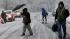 People walk in a snowfall Wednesday, Nov. 7,...