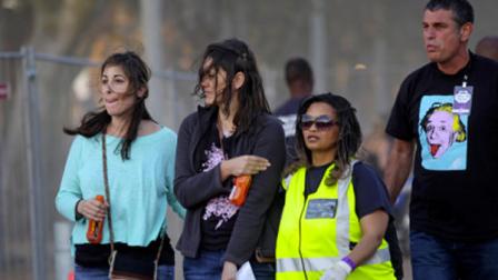 A injured woman, second left, holds her arm as she walks with medical personnel, second right, after she and others were injured during a concert by Linkin Park in Cape Town, South Africa, Saturday, Nov. 7, 2012. The city of Cape Town, South Africa, says that 20 people have been injured after scaffolding collapsed because of high winds outside a concert for Linkin Park. (AP Photo)