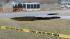 A massive sinkhole, at least 30 feet wide and 15...