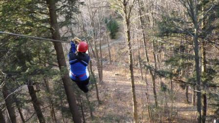 This Sunday, Nov. 21, 2010 photo courtesy of Smugglers Notch Resort shows a Smugglers Notch employee taking a ride on the the zip line canopy tour at Smugglers Notch Resort in Smugglers Notch, Vt.