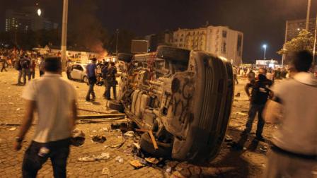 Protesters look a destroyed car during a rally at the Taskim square in Istanbul early Sunday, June 2, 2013. Public anger has flared among urban and secular Turks after police violently broke up an anti-development sit-in in the landmark Taksim Square, with protests spreading to dozens of other cities as demonstrators denounced what they see as Prime Minister Recep Tayyip Erdogans increasingly authoritarian style.