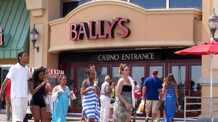 In this June 27, 2013 photo, pedestrians walk on the Atlantic City N.J. Boardwalk past the Ballys Atlantic City casino. Atlantic Citys 12 casinos saw their collective earnings fall by nearly 45 percent in the second quarter of 2013, state regulators said Thursday, Aug. 22, 2013.