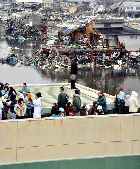 Houses, cars and other debris are washed away...