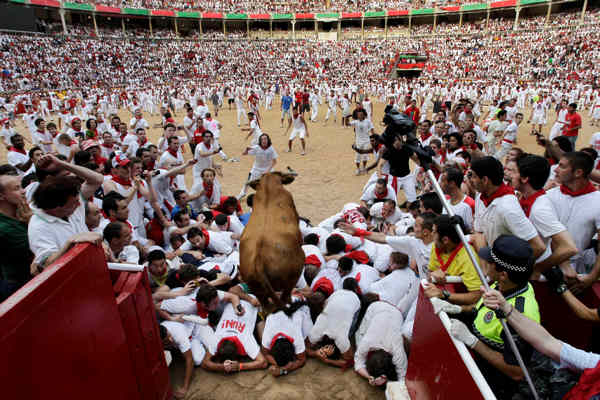 Revelers run in front of a Jandilla ranch...