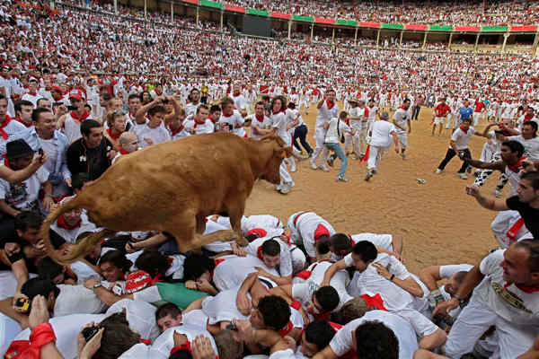 Revelers run in front of a Jandilla ranch...