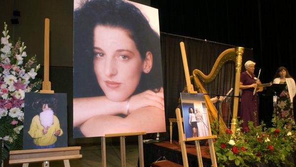 Photos of Chandra Levy are on display as musicians, right, stand by at the memorial service for Levy in this Tuesday, May 28, 2002 file photo taken at the Modesto Centre Plaza in Modesto, Calif. Media reports Saturday Feb. 21, 2009 in Washington and California say that an arrest may be close in the slaying of the former federal intern whose disappearance ended Gary Condits congressional career. The warrant is expected to be for a prison inmate convicted of attacking two female joggers in the same Washington park where Levys remains were found. (AP Photo/Debbie Noda, Pool, File)