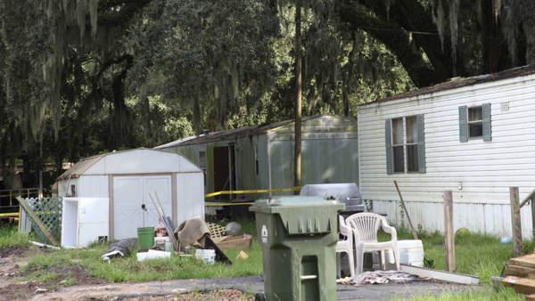 The house at New Hope Mobile Home Park in Brunswick, Ga where seven people were found slain Saturday morning is surrounded with police tape Saturday, Aug. 29, 2009. Seven people were found slain and two critically injured Saturday at a mobile home located on a historic plantation in southeastern Georgia, police said. (AP Photo/Lewis Levine)