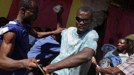 Men fight over goods stolen from a store in downtown Port-au-Prince, Thursday, Jan. 21, 2010. Sporadic looting continued in the capital as people scavenged in the rubble left by the earthquake that hit Haiti on Jan. 12. (AP Photo/Ramon Espinosa)