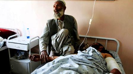 An unidentified father comforts his injured son at a hospital following a blast at wedding party in Kandahar city, Afghanistan, Thursday, June 10, 2010. A suicide attack ripped through a wedding party.