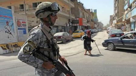 An Iraqi police officer stands at a checkpoint in central Baghdad, Iraq