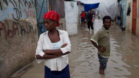 People stand in a flooded street after the passing of Hurricane Tomas in the neighborhood of Cite Soleil in Port-au-Prince, Haiti, Saturday Nov. 6, 2010. (AP Photo/Ramon Espinosa)