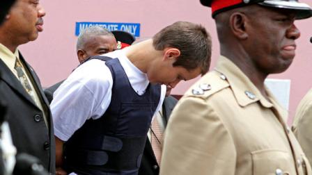 Colton Harris-Moore, the teenage fugitive police have dubbed the Barefoot Bandit, is escorted handcuffed by Bahamian authorities to the court building in Nassau, Tuesday July 13, 2010. Harris-Moore, who was captured following a high-speed boat chase on Sunday in Eleuthera island, pleaded guilty to a minor offense in the Bahamas and is expected to be deported soon to the U.S. to face prosecution. (AP Photo/Tim Aylen)