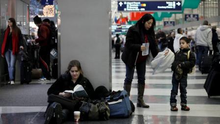 Grace Carini, reads a book as she waits for her mother to pick her up after traveling from South Bend, Ind., while Alma Dynia and her son Nathan, right, wait for their flight to Seattle at OHare International Airport, Wednesday, Nov. 24, 2010, in Chicago. Holiday travelers at OHare incurred few problems today as expected protests against Transportation Security Administration screening procedures, using full body scanners and pat downs failed to materialize. (AP Photo/M. Spencer Green)