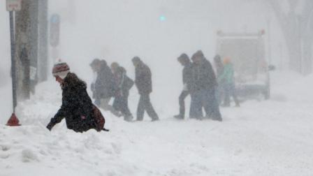 Pedestrians make their way to a Minnesota college basketball game against Eastern Kentucky on the University of Minnesota campus during a snowstorm in Minneapolis, Saturday, Dec. 11, 2010. (AP Photo/Ann Heisenfelt)