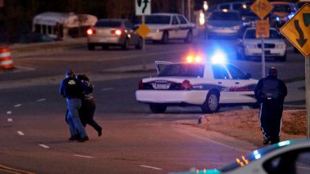 Police run with a hostage at a Wachovia Bank in Cary, N.C., where an armed man took four people hostage Thursday, Feb. 10, 2011. Television footage shows the subject was shot as he exited the bank with a hostage. (AP Photo/Gerry Broome)
