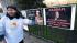 A Libyan activist talks next to posters...