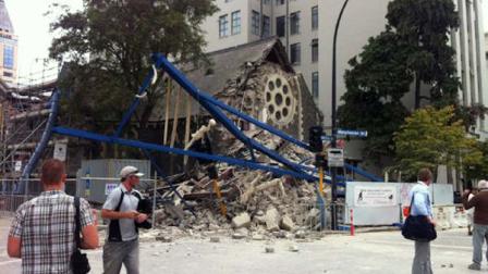 People look at a damaged church after a powerful earthquake struck Christchurch, New Zealand, Tuesday, Feb, 22, 2011. The 6.3-magnitude quake collapsed buildings and is sending rescuers scrambling to help trapped people amid reports of multiple deaths. (AP Photo/Layton Duncan)