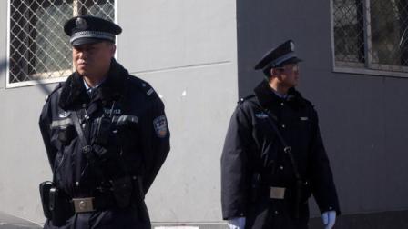 Chinese police officers stand on duty near the Xidan shopping district, one of two sites designated on an Internet call for protest, in Beijing Sunday, March 6, 2011. The Chinas capital is increasing its controls on foreign journalists amid calls on the Internet for anti-government protests styled on those rocking the Middle East and North Africa.
