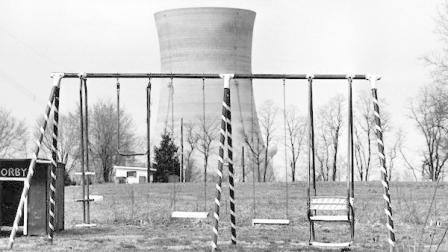 FILE - This file photo from March 30, 1979 shows a cooling tower of the Three Mile Island nuclear power plant near Harrisburg, Pa., as it looms behind an abandoned playground. The partial meltdown at Three Mile Island nuclear plant in 1979 routed more than 180,000 people living within 50 miles of the plant. (AP Photo/Barry Thumma, File)