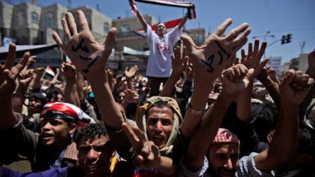 Anti-government protestors gesture during a demonstration demanding the resignation of Yemeni President Ali Abdullah Saleh, in Sanaa, Yemen, Tuesday, March 22, 2011. Yemens embattled U.S.-backed president said Tuesday that a military coup would lead to civil war and pledged to step down by years end but not hand power to army commanders who have joined the opposition. Arabic on the demonstrators hands reads, Leave. (AP Photo/Muhammed Muheisen)